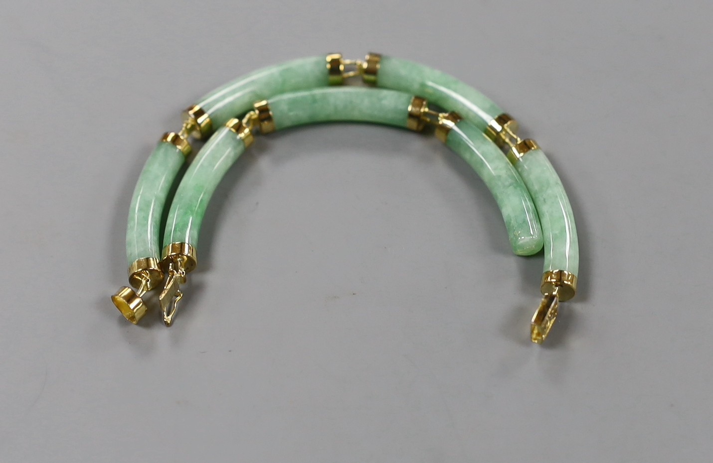 A modern Chinese 14k yellow metal and curved jade link bracelet (a.f.), approx. 20cm, gross 13.7 grams.